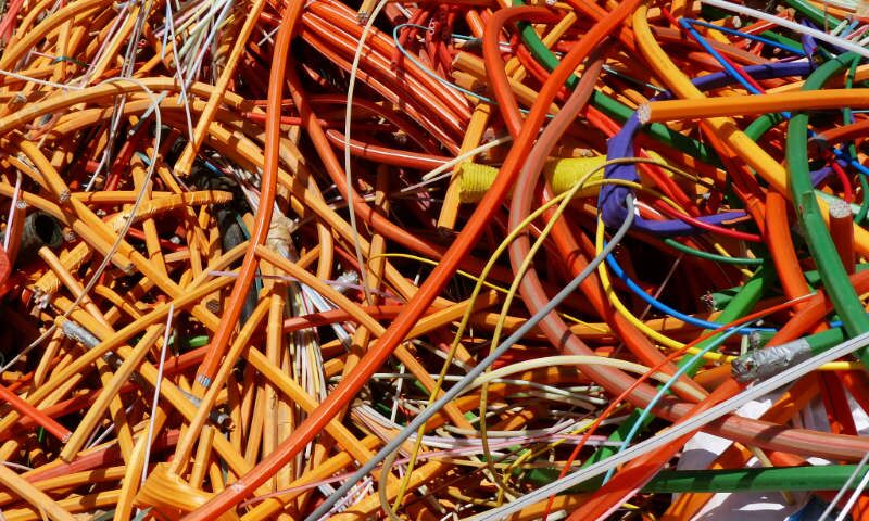 Mit Kunststoff isolierte Kabel unterschiedlicher Größen und Farben lagern unsortiert, ineinander verwoben vor ihrer Weiterverarbeitung im Recyclingsystem auf dem Gelände des Entsorgungsunternehmens Xpress Plastics.