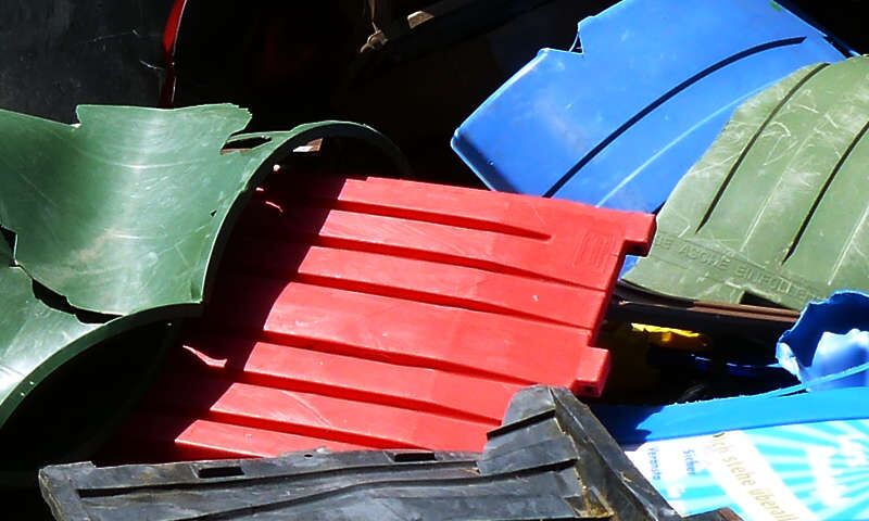 Kaputte Kunststoffmülltonnen und Kunststoffeimer unterschiedlicher Färbung liegen zusammengewürfelt auf dem Gelände des Entsorgungsunternehmens Xpress Plastics GmbH, Plastics Recycling Management in Biebesheim am Rhein.