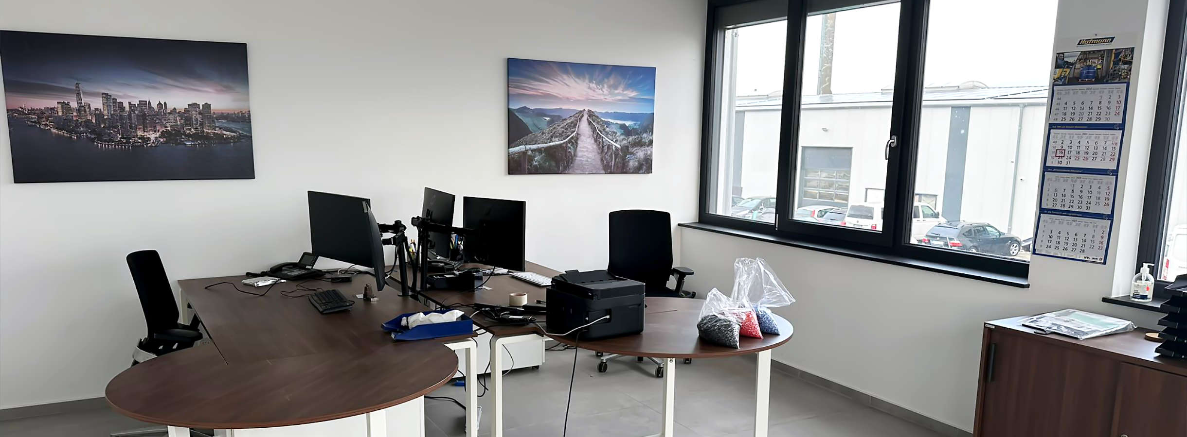 Ein lichtdurchfluteter weiter Büroinnenraum des Recycling-Unternehmens Xpress Plastics. Weiße Wände, inspirative Wandbilder, gemütliche Sessel, praktische Tische mit modernen EDV-Geräten gewähren eine angenehme Arbeitsatmosphäre in der Recycling-Firma.