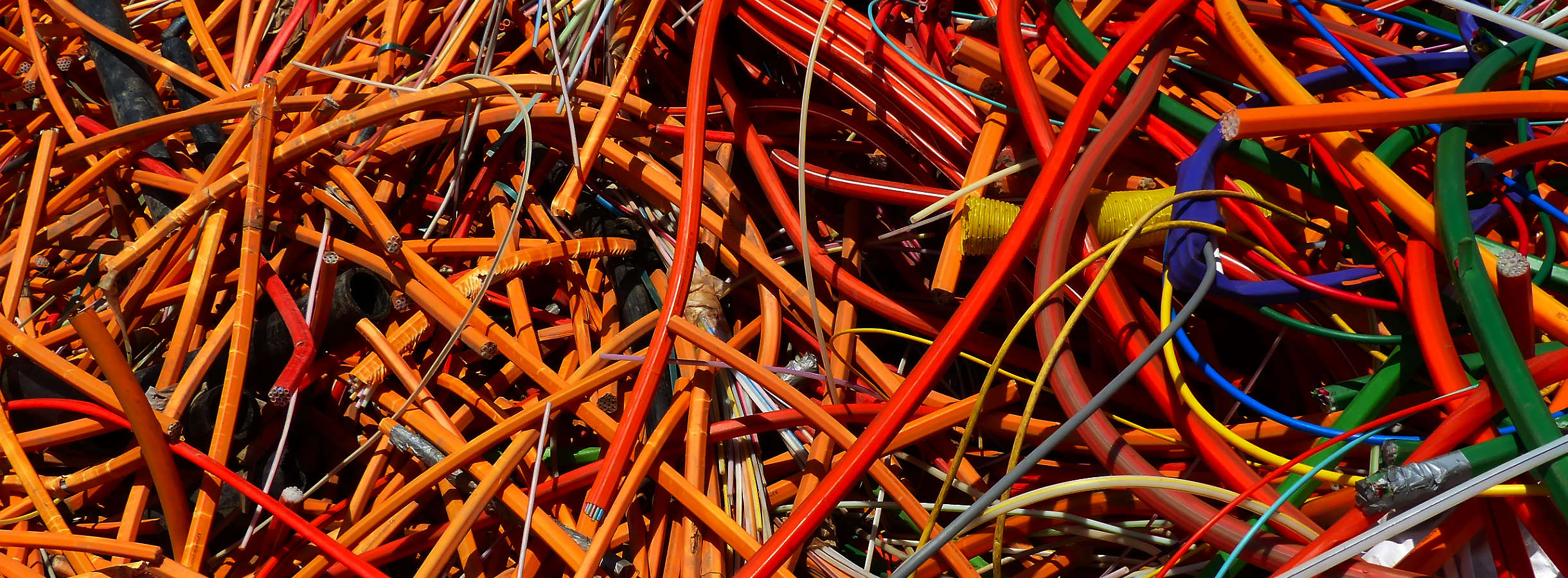 Kabelsalat aus mit Kunststoff isoliertem Kabelstrang unterschiedlicher Farben. Das Durcheinander eines reklamierten Auftrages wird nach Sorten geordnet und für einen spezialisierten Recyclingprozess dem Umweltschutz entgegenwirkend vorbereitet.