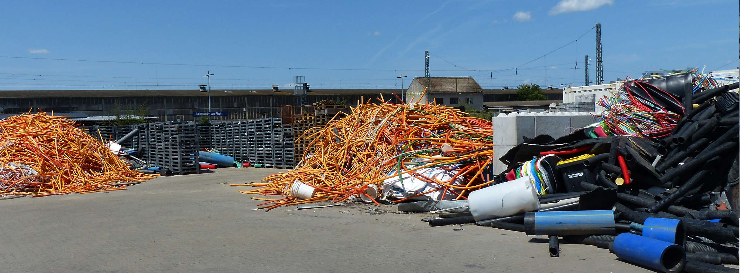 Ablageplatz auf dem Gelände des Werksentsorgers für Kunststoffabfälle im Rhein-Main-Gebiet und Großraum Hamburg. Produktionsreste, Ausschussware und Verpackungskunststoffe unterschiedlicher Farben und Formen liegen nach Sorte zu Haufen geordnet.